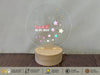 a personalized acrylic snow globe on a wooden stand