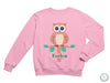 a pink sweatshirt with an owl sitting on a branch