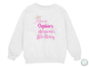 a white sweatshirt with pink lettering and a crown on it