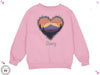 a pink sweatshirt with a heart and mountains in the background