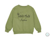 a green sweatshirt with the words wild child and a dandelion